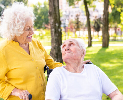 Senior Couple With Disability Walking At The Park